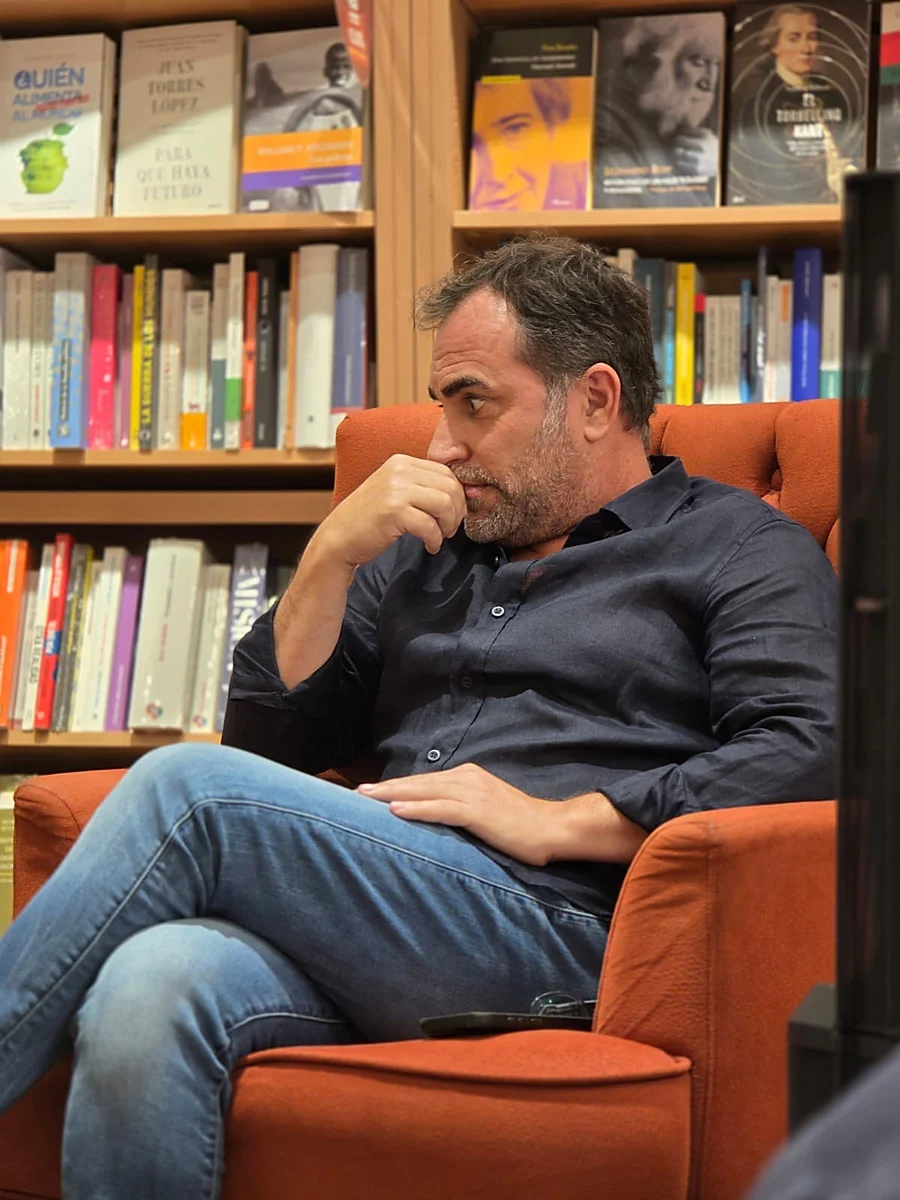 Miki Obradors en una entrevista, rodeado de libros