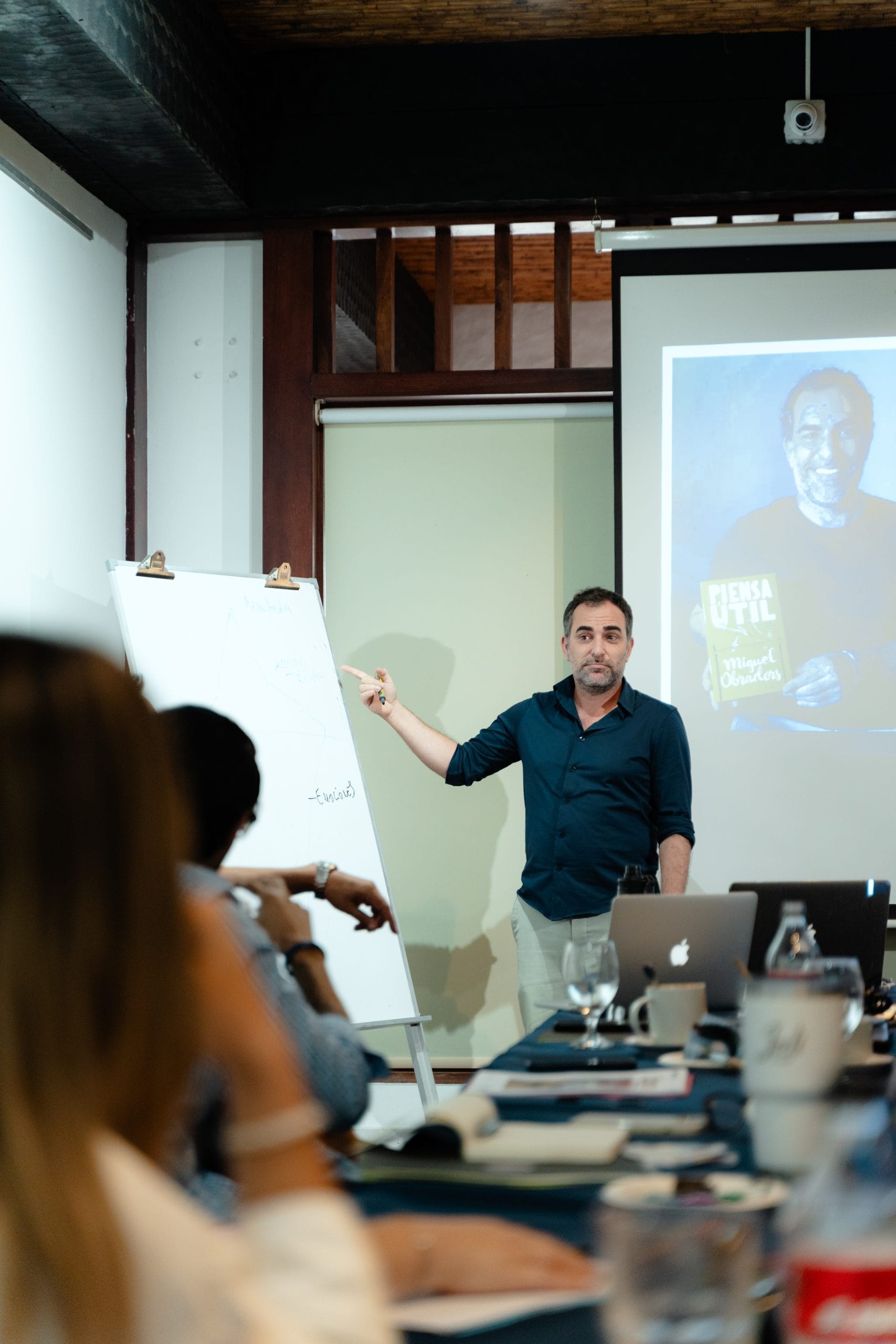 Miki Obradors dando un taller a directivos, con su libro Piensa Útil proyectado detrás